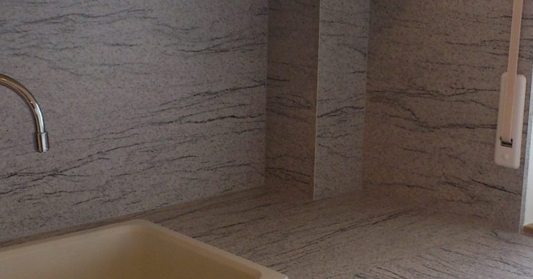 perfekte Montage Küchenzeile mit Spüle und grauem Wand- und Arbeitsplattenbelag.
